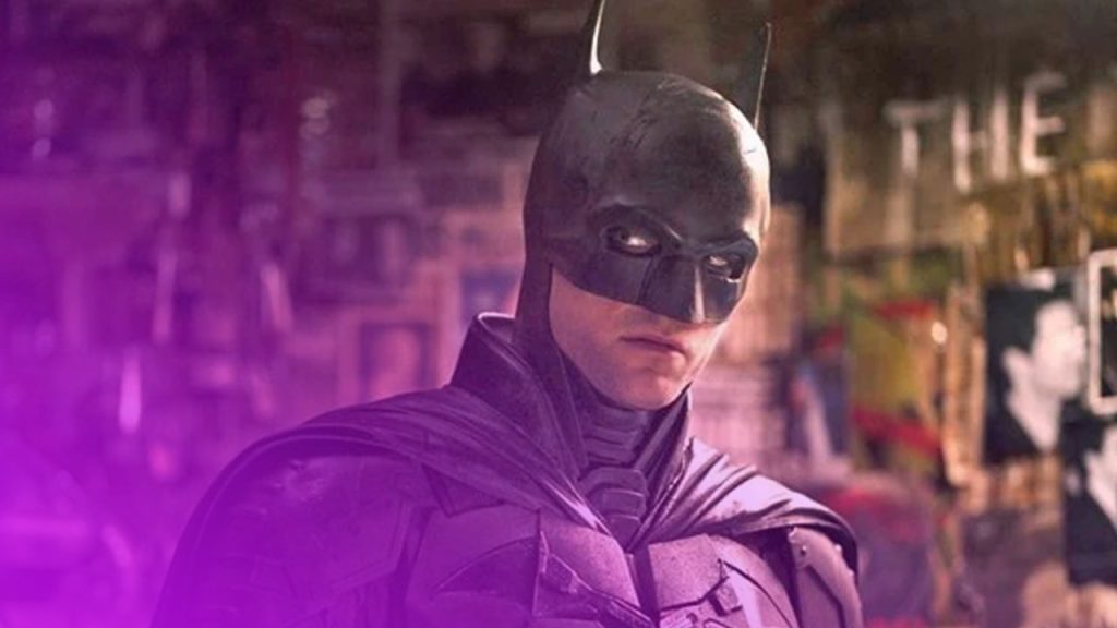 Halbporträt von Batman, der einen schwarzen, kantigen Anzug und eine Maske mit spitzen Ohren trägt. Seine Augen sind von schwarzer Schminke umgeben, die einen intensiven Blick erzeugt. Er steht in einem düsteren Raum, der mit Zeitungsartikeln, Fotos und Graffiti-Postern tapeziert ist, die im Hintergrund verschwommen zu erkennen sind. Die Beleuchtung ist dunkel und akzentuiert seine Gesichtszüge und Rüstung.