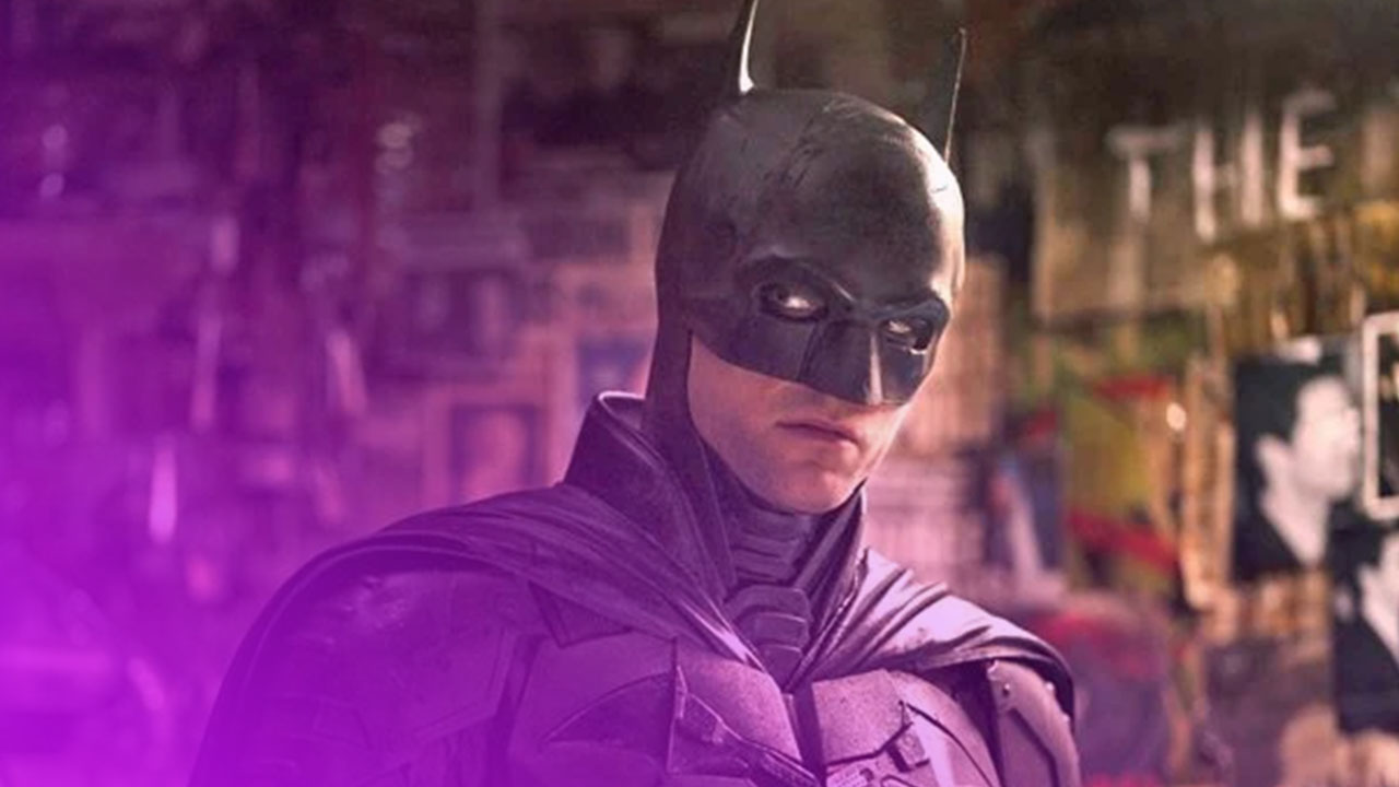 Halbporträt von Batman, der einen schwarzen, kantigen Anzug und eine Maske mit spitzen Ohren trägt. Seine Augen sind von schwarzer Schminke umgeben, die einen intensiven Blick erzeugt. Er steht in einem düsteren Raum, der mit Zeitungsartikeln, Fotos und Graffiti-Postern tapeziert ist, die im Hintergrund verschwommen zu erkennen sind. Die Beleuchtung ist dunkel und akzentuiert seine Gesichtszüge und Rüstung.