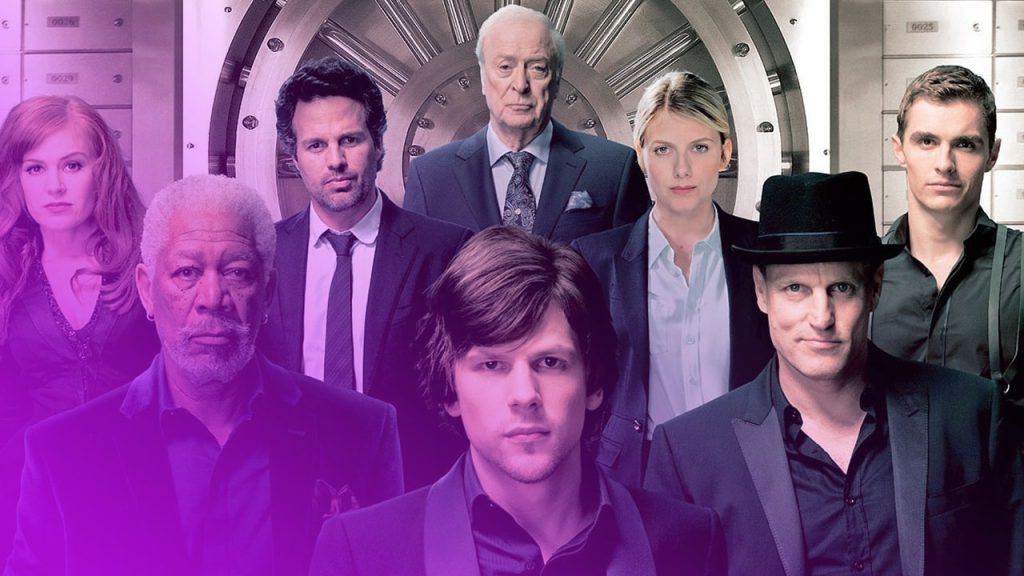 Posterbild des Films "Die Unfassbaren" mit sieben Hauptdarstellern. Im Vordergrund sind Woody Harrelson (rechts, mit schwarzem Zylinder), Jesse Eisenberg (Mitte) und Morgan Freeman (links, mit grauem Bart) zu sehen. Im Hintergrund, in einer zweiten Reihe, stehen von links nach rechts Isla Fisher (mit langen roten Haaren), Mark Ruffalo, Michael Caine (der älteste der Gruppe) und Dave Franco. Sie stehen vor einem großen, runden Tresorraum, der von Fächern und Schließfächern umgeben ist, und blicken alle direkt in die Kamera. Die Kleidung der Darsteller ist elegant, überwiegend in Schwarz, Blau und Weiß gehalten.