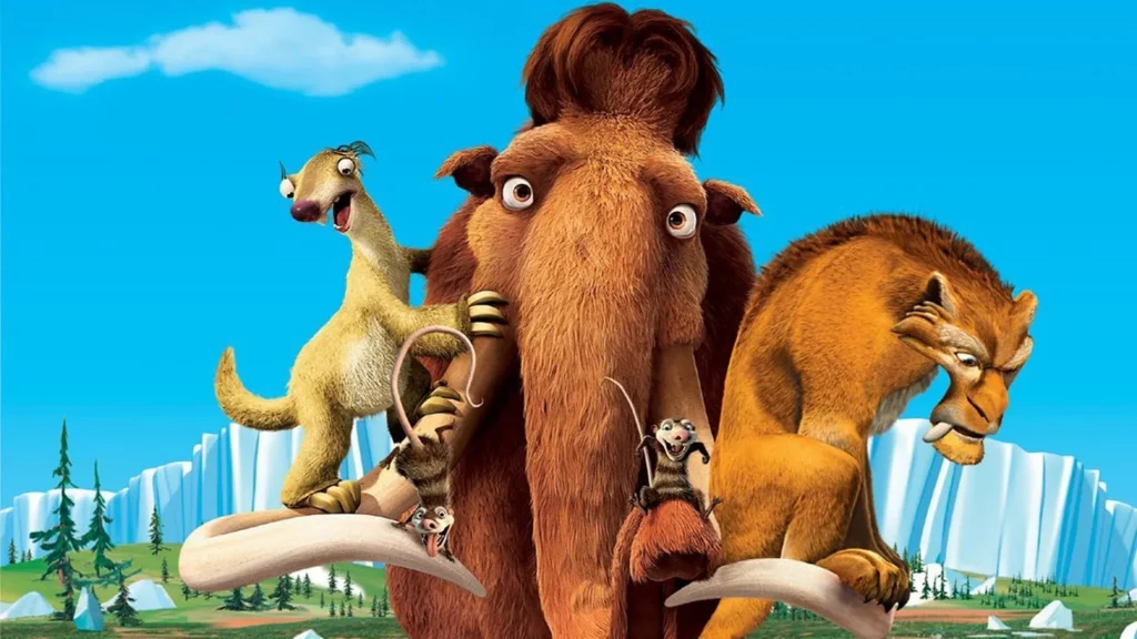 Das Bild zeigt drei anthropomorphe, prähistorische Tiere aus dem Animationsfilm **Ice Age** in einer Landschaft aus Eis, Schnee und Wäldern. In der Mitte steht ein großes, braunes Mammut mit weitem Blick und einem kleineren, braunen Tier mit einem langen Schwanz, das auf einem seiner Stoßzähne sitzt. Links davon steht ein blasses, braunes Faultier mit einem breiten Grinsen und erhobenem Arm. Rechts steht ein orangefarbener Säbelzahntiger mit einem ernsten, grimmigen Ausdruck. Die Tiere stehen vor einem hellblauen Himmel und einer Berglandschaft aus Eis.