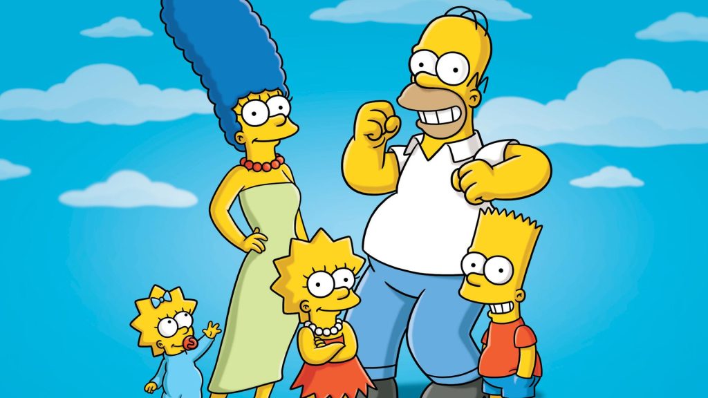 Zwei Comicfiguren für Erwachsene, die gelbe Haut und große, runde Augen haben, stehen vor einem hellblauen Himmel mit einigen weißen Wolken. Homer Simpson mit Glatze und weißem Polohemd, lächelt breit und hebt seine rechte Hand in einer triumphierenden Geste. Neben ihm steht Marge Simpson mit ihrer charakteristischen hohen, blauen Turmfrisur, einem langen, hellgrünen, trägerlosen Kleid und einer roten Perlenkette. Im Vordergrund stehen die drei Kinder, ebenfalls gelb: die kleine Maggie Simpson mit rotem Schnuller, die intellektuelle Lisa Simpson in einem roten Kleid und einer weißen Perlenkette, die ihre Arme verschränkt hält, und der ältere Sohn Bart Simpson in einem orangefarbenen Hemd und blauen Shorts, der grinst. Alle fünf blicken den Betrachter an.