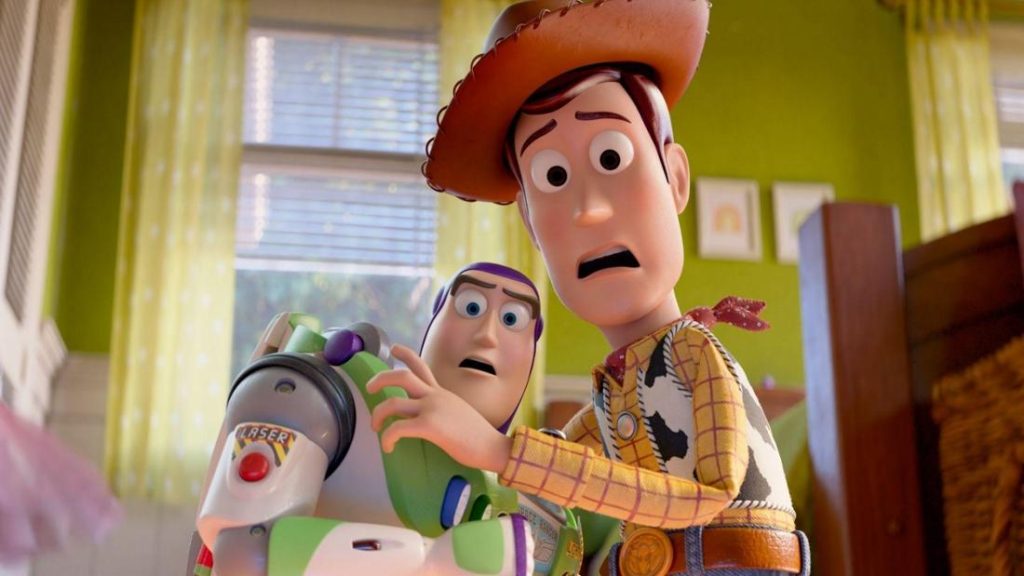 Woody, der Cowboy, hält den Space Ranger Buzz. Beide Spielzeuge blicken schockiert mit großen Augen und offenen Mündern in einem Kinderzimmer.