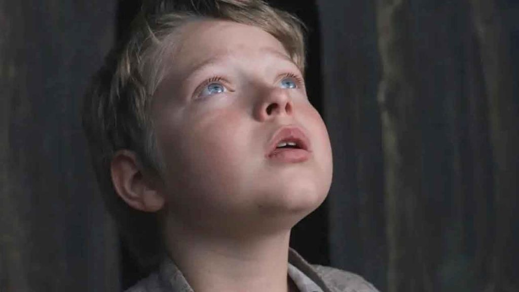 Nahaufnahme eines blonden Jungen, der mit offenem Mund und glänzenden Augen andächtig nach oben blickt.