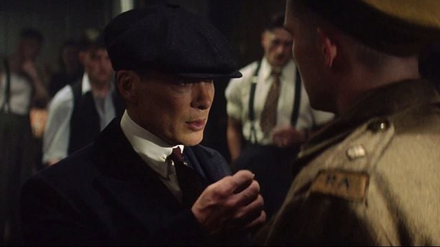 Ein Mann mit Schiebermütze starrt einem Soldaten in Uniform intensiv ins Gesicht. Düstere, konfrontative Stimmung.