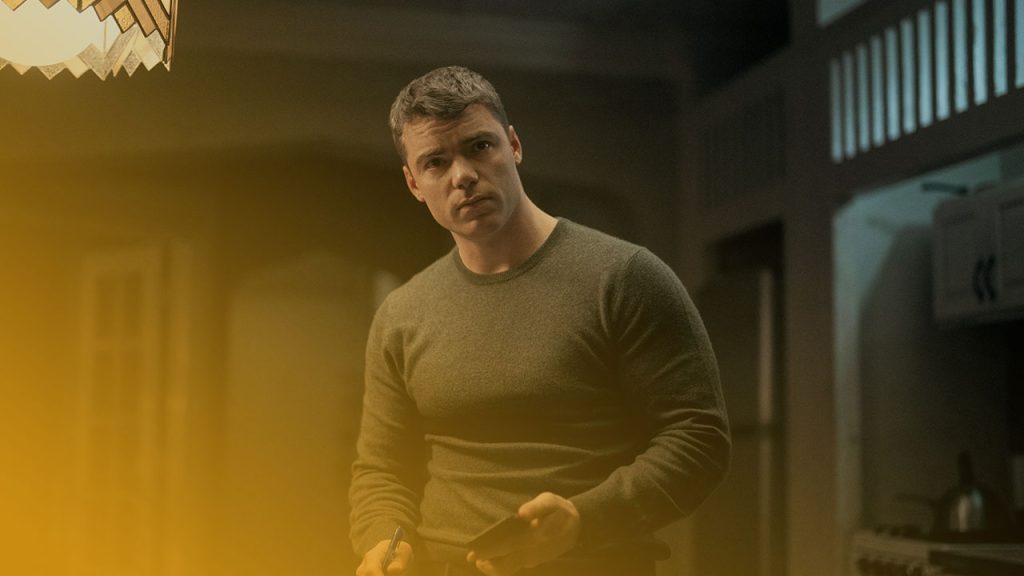 Ein Mann im grauen Pullover blickt besorgt, während er ein Smartphone und einen Stift in den Händen hält.