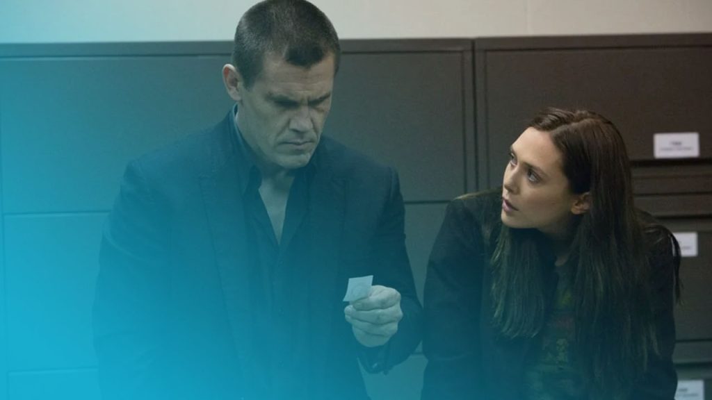 Josh Brolin und Elizabeth Olsen blicken ernst auf einen kleinen Zettel vor dunklen Aktenschränken.