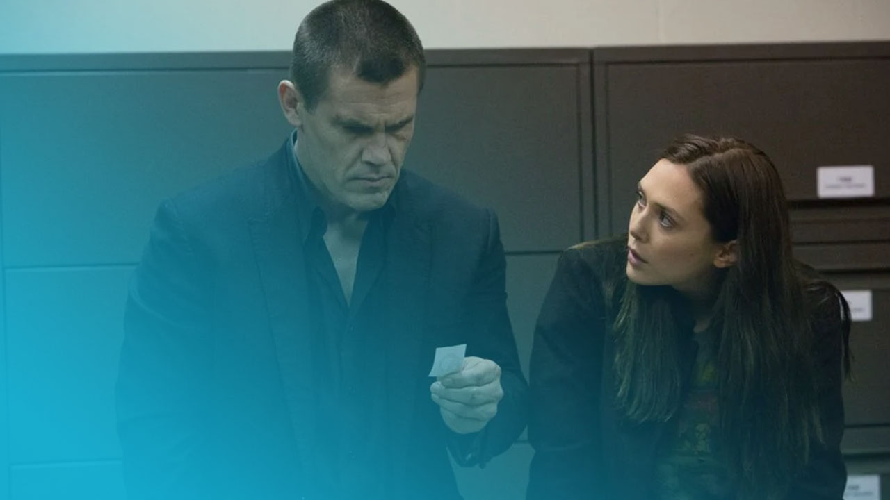 Josh Brolin und Elizabeth Olsen blicken ernst auf einen kleinen Zettel vor dunklen Aktenschränken.