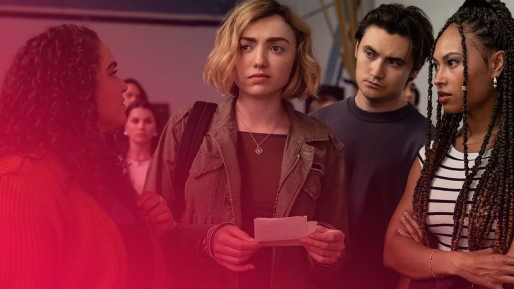 Vier junge Erwachsene stehen in einer heller beleuchteten Halle. Eine Frau mit blonden, kurzen Haaren und grüner Jacke hält einen Zettel und blickt besorgt. Links spricht eine Frau mit lockigem Haar zu ihr, rechts stehen eine Frau mit Zöpfen und ein Mann mit ernstem Gesichtsausdruck.