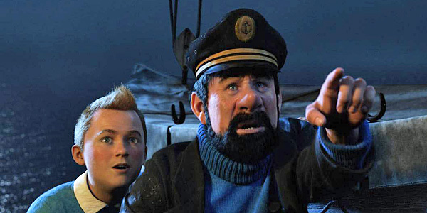 Ein bärtiger Kapitän in Uniform und Mütze zeigt aufgeregt nach vorne, während ein Junge neben ihm auf einem Boot im Meer steht.