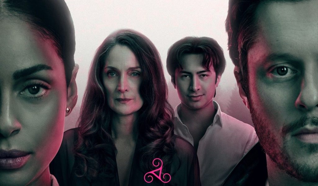 Ein Poster zeigt die Gesichter von vier Personen – zwei Frauen und zwei Männer – in einer düsteren, nebligen Atmosphäre mit rosa und grünlichem Licht. Im Vordergrund ist ein stilisiertes, pinkfarbenes Symbol zu sehen. Die Personen blicken ernst und direkt in die Kamera.
